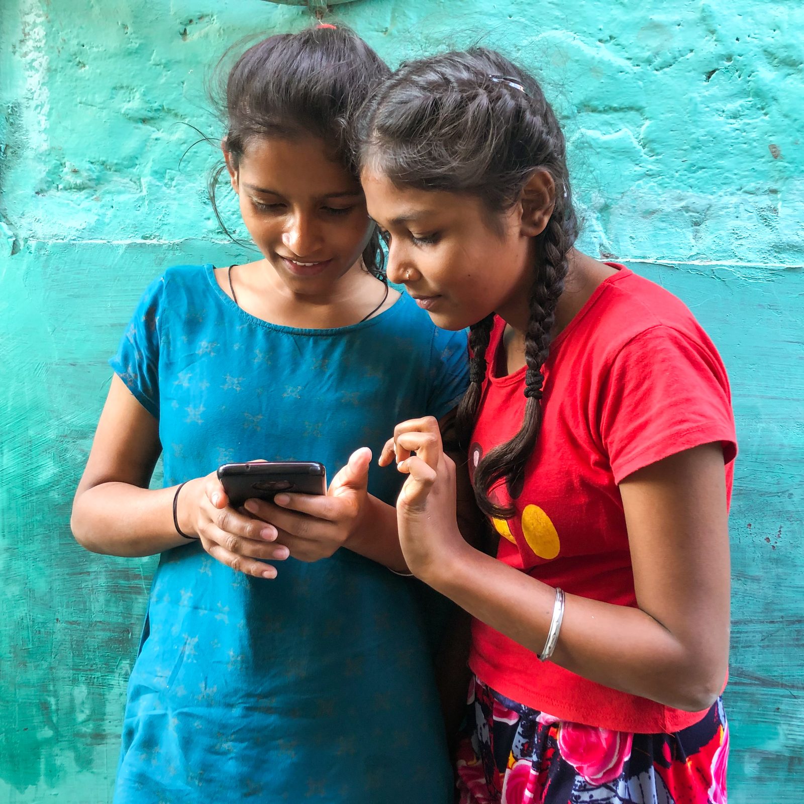 Two adolescent girls with a phone