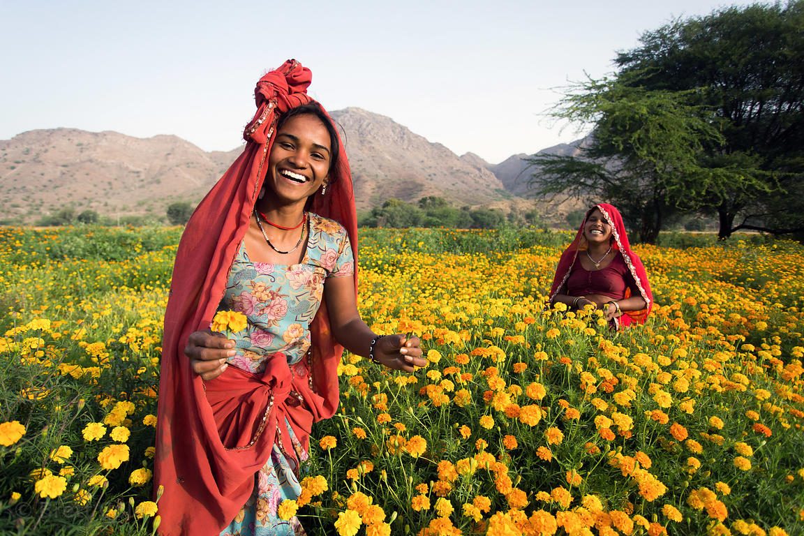A woman laughing in a marigold field